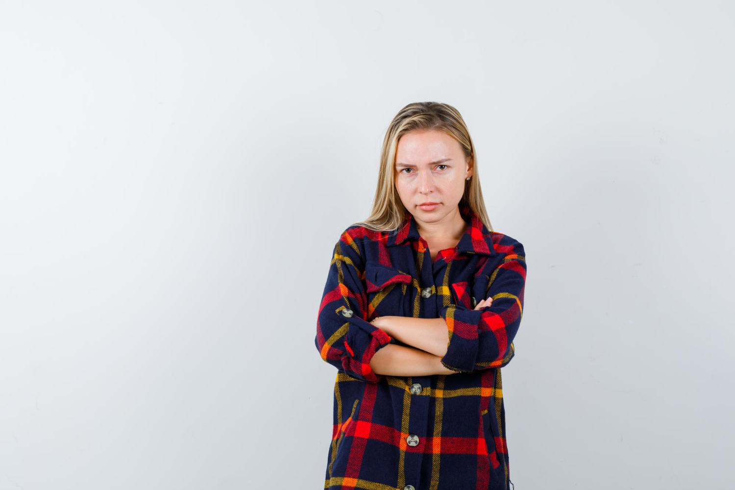 Una giovane donna arrabbiata con le braccia incrociate | Fonte: Freepik