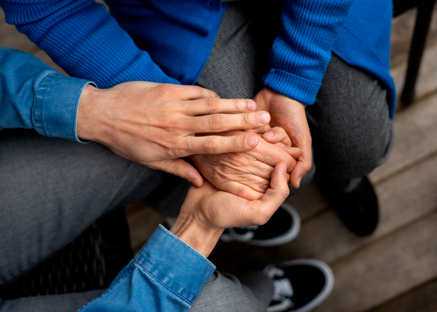 Primo piano di un uomo che prende la mano di una persona anziana | Fonte: Freepik