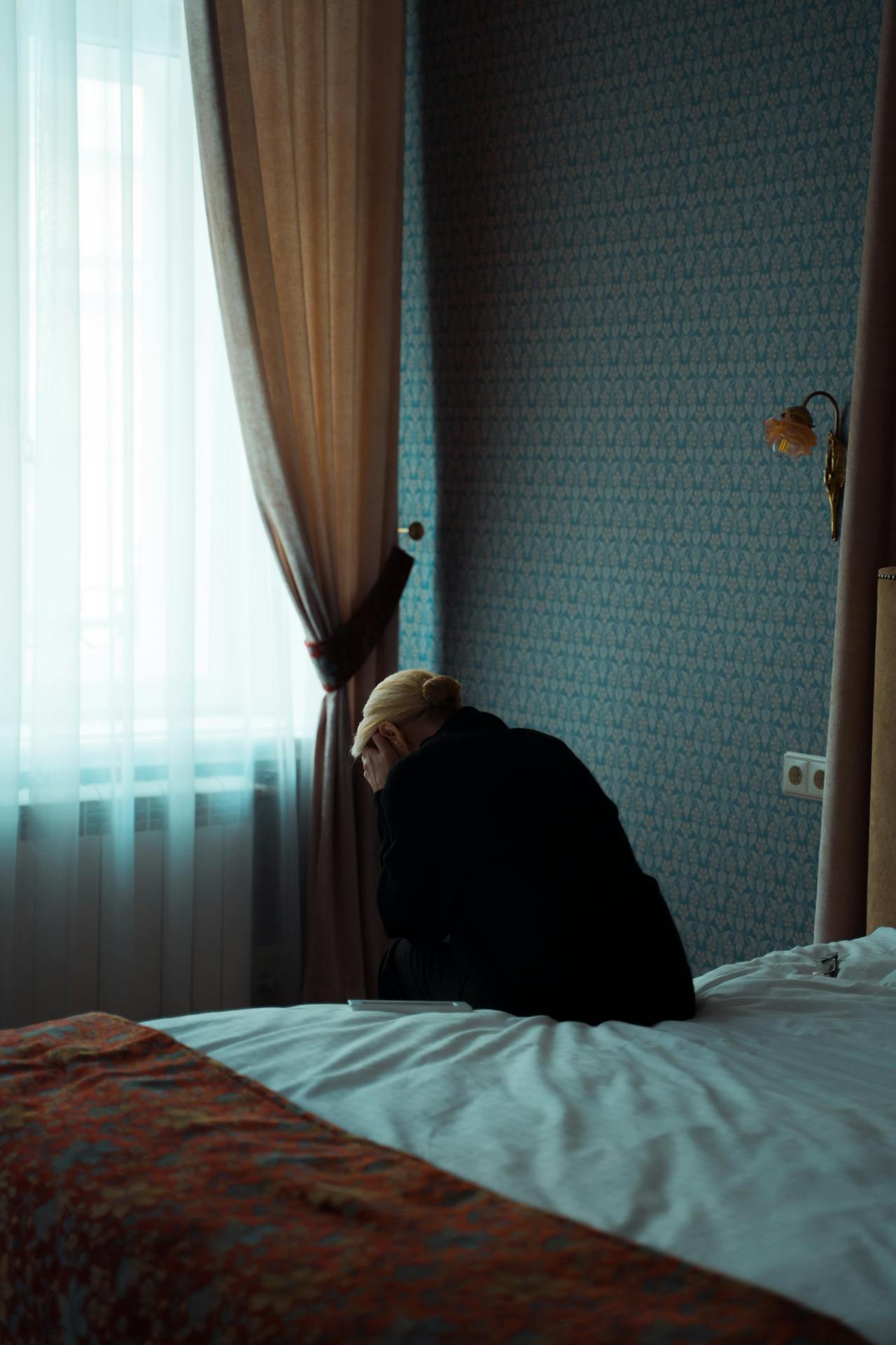 Una donna sola e depressa seduta sul letto | Fonte: Pexels